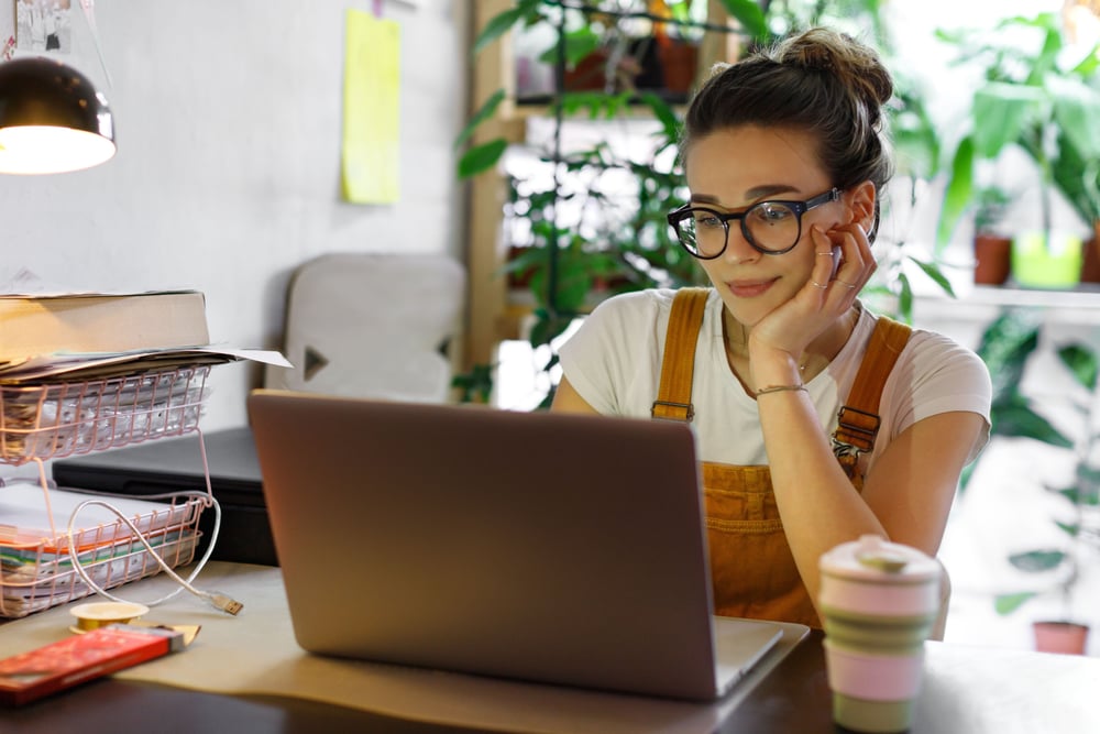 Young woman with glasses completing her customized staff training course from home